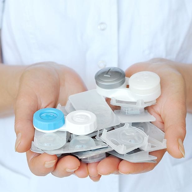 Manos con blísters de lentillas y estuche portalentillas 