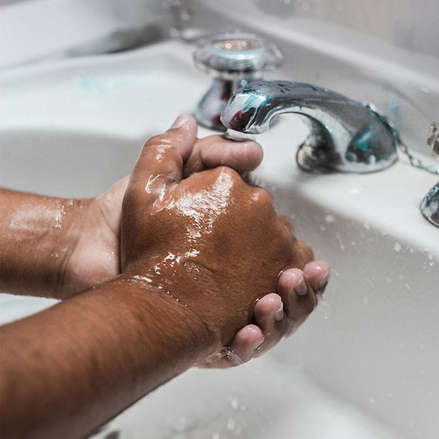 Persona lavándose las manos en el lavabo 