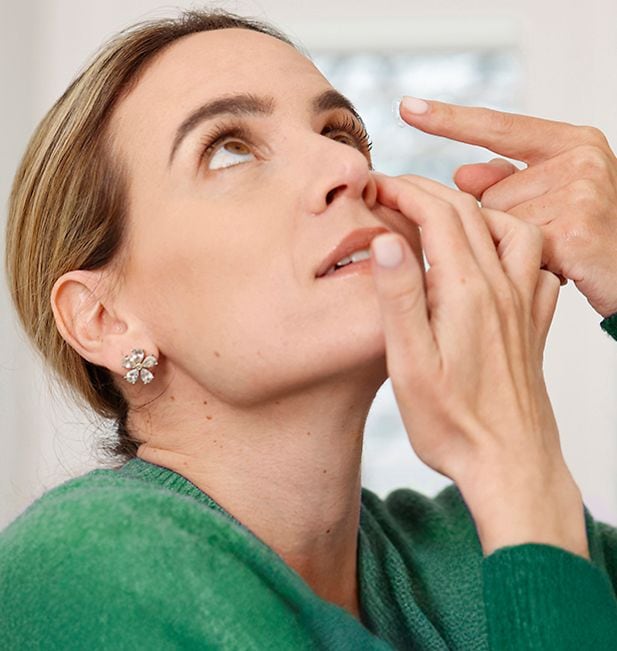 Hombre añade líquido a un estuche para lentillas.